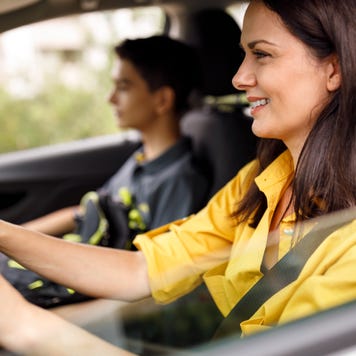 Close up of mother driving teenage son