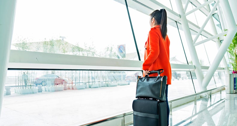 Woman looking out of airport window © iStock