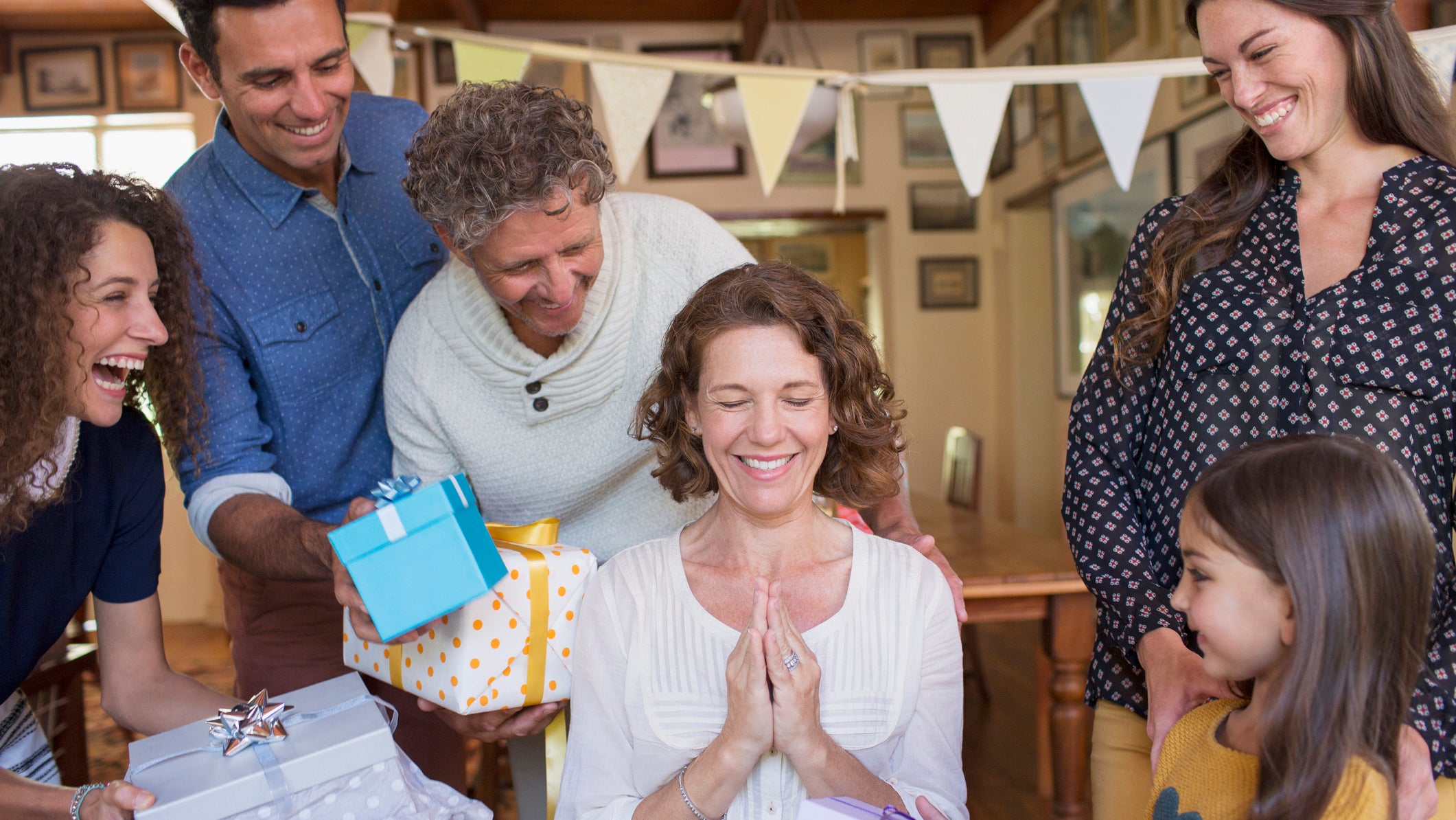 Older woman being given gift by family