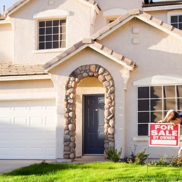 Home seller putting a for sale sign in yard