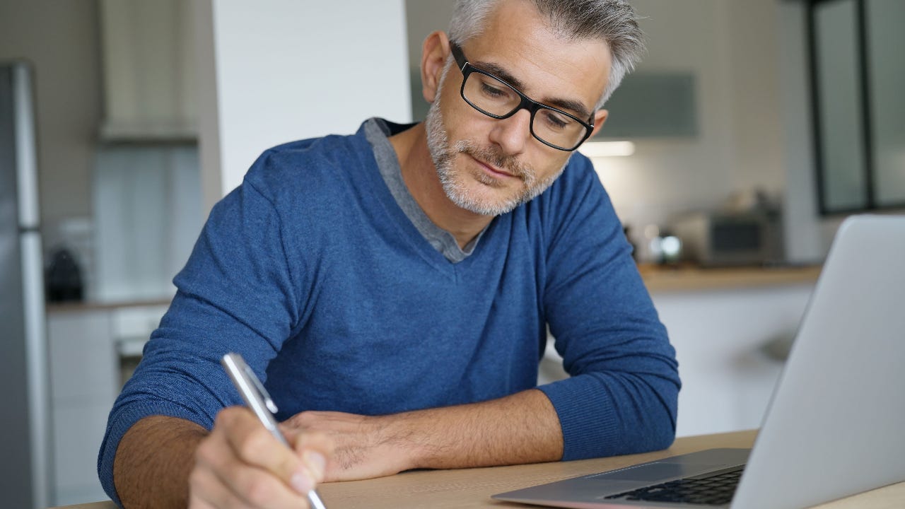 Person on computer also writing