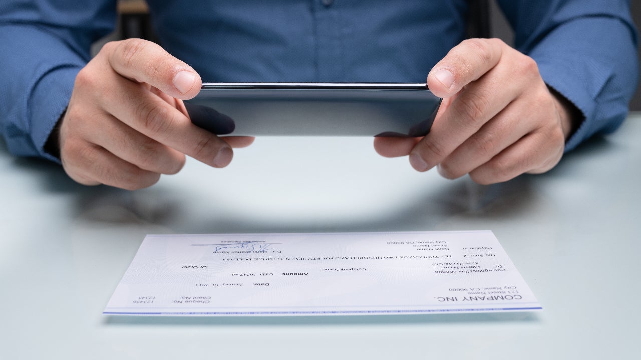 A person takes a picture of a check.