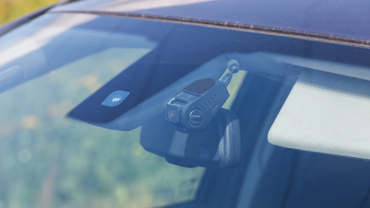 Shot of a dash cam seen through the front of a windshield.