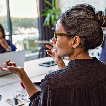 business woman talking to colleagues in a meeting