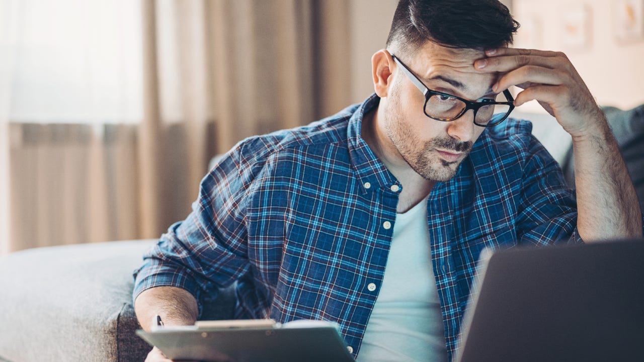 Confused young man working at home