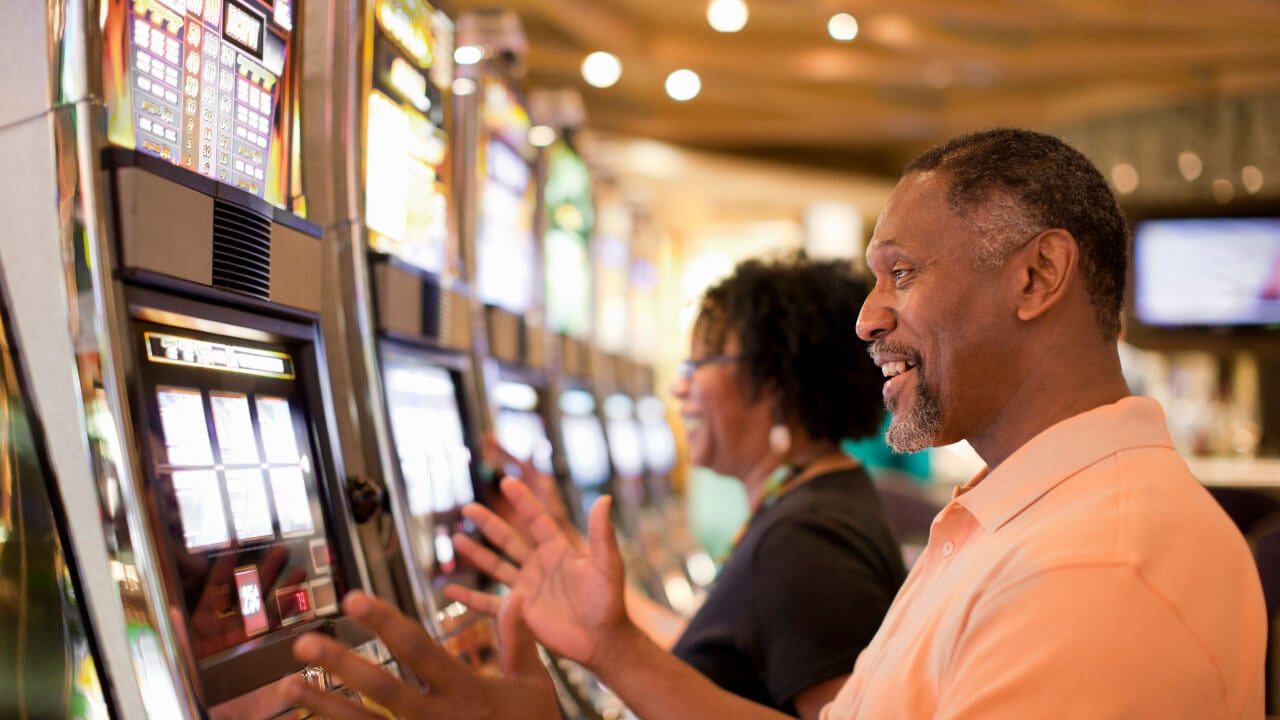 Couple playing slot machines at a casino