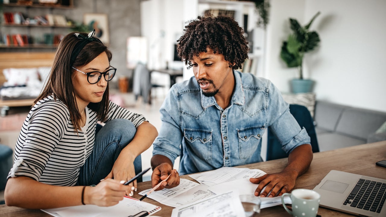 Multi-ethnic couple planning their home budget