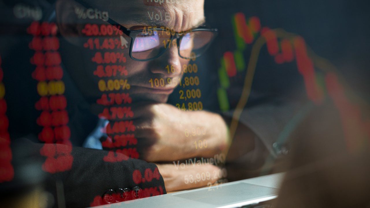 Man looks at financials on screen