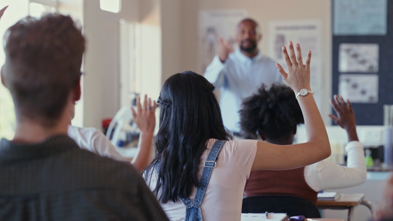 High school teacher calls on students in classroom