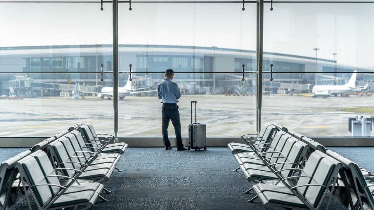 man looking out the window while waiting at an airport