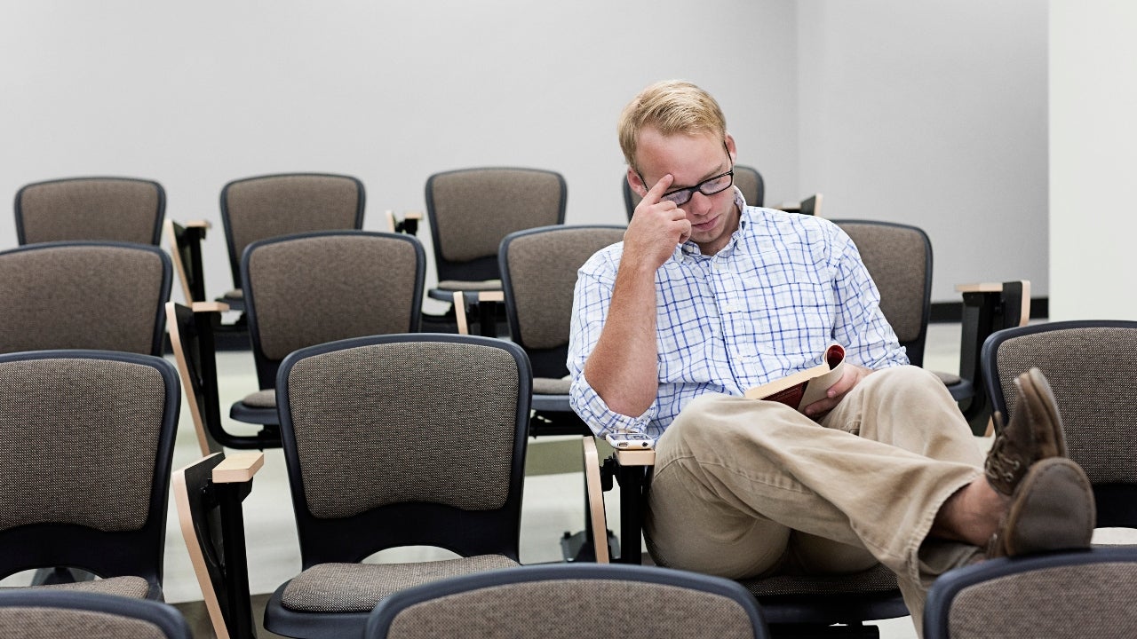 Student sits alone in classroom reading