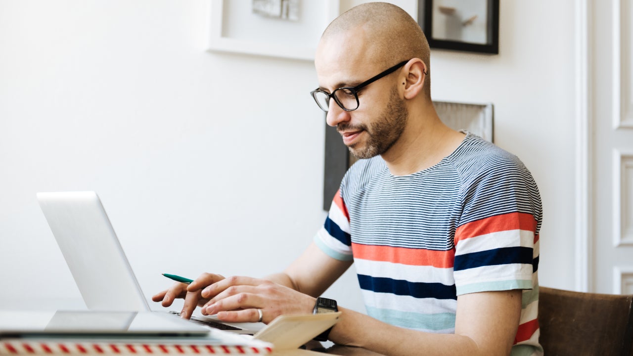 Bald Man Working On Laptop At Home