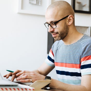 Bald Man Working On Laptop At Home