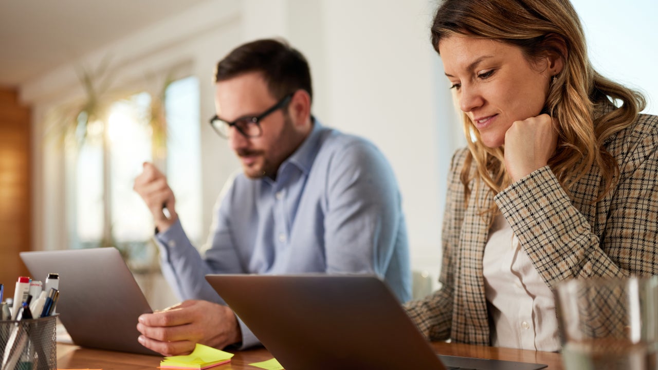 Young business couple working on computers at home office.