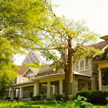 A row of houses surrounded by green grass and trees