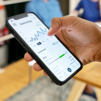 Close-up of woman trading stock online on mobile phone