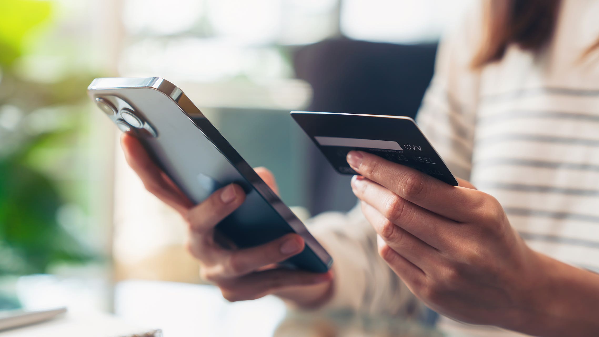 Woman holding credit card and mobile phone