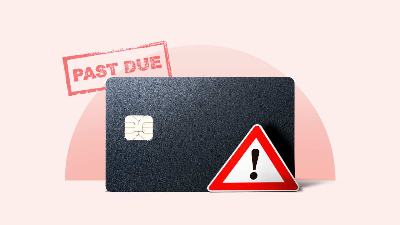 Credit card with a past-due stamp and warning sign on it.