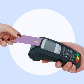 Hand tapping a credit card on a POS machine.