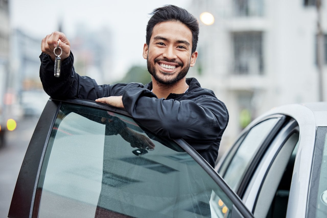 New car, city and portrait of man with keys after vehicle purchase to drive, transport and travel on street. Transportation, loan approval and happy person with freedom for trip, journey or adventure