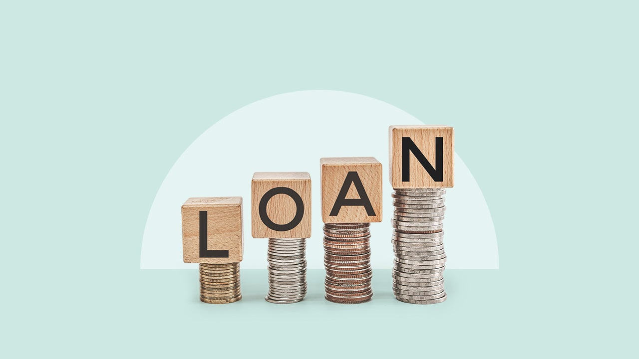 Scrabble tiles perched atop coins spelling out the word LOAN.