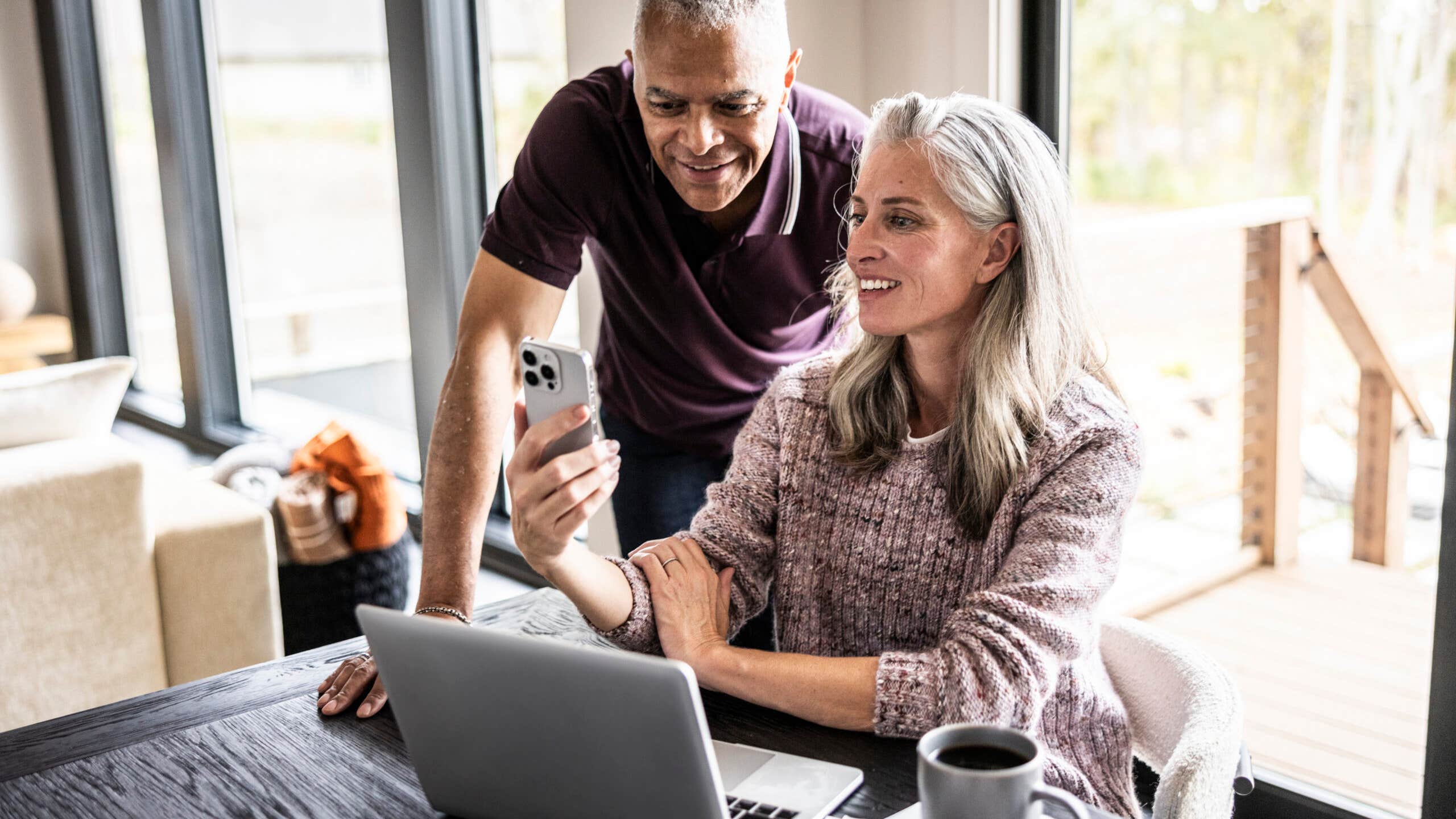 Couple looking at a laptop and a smartphone.