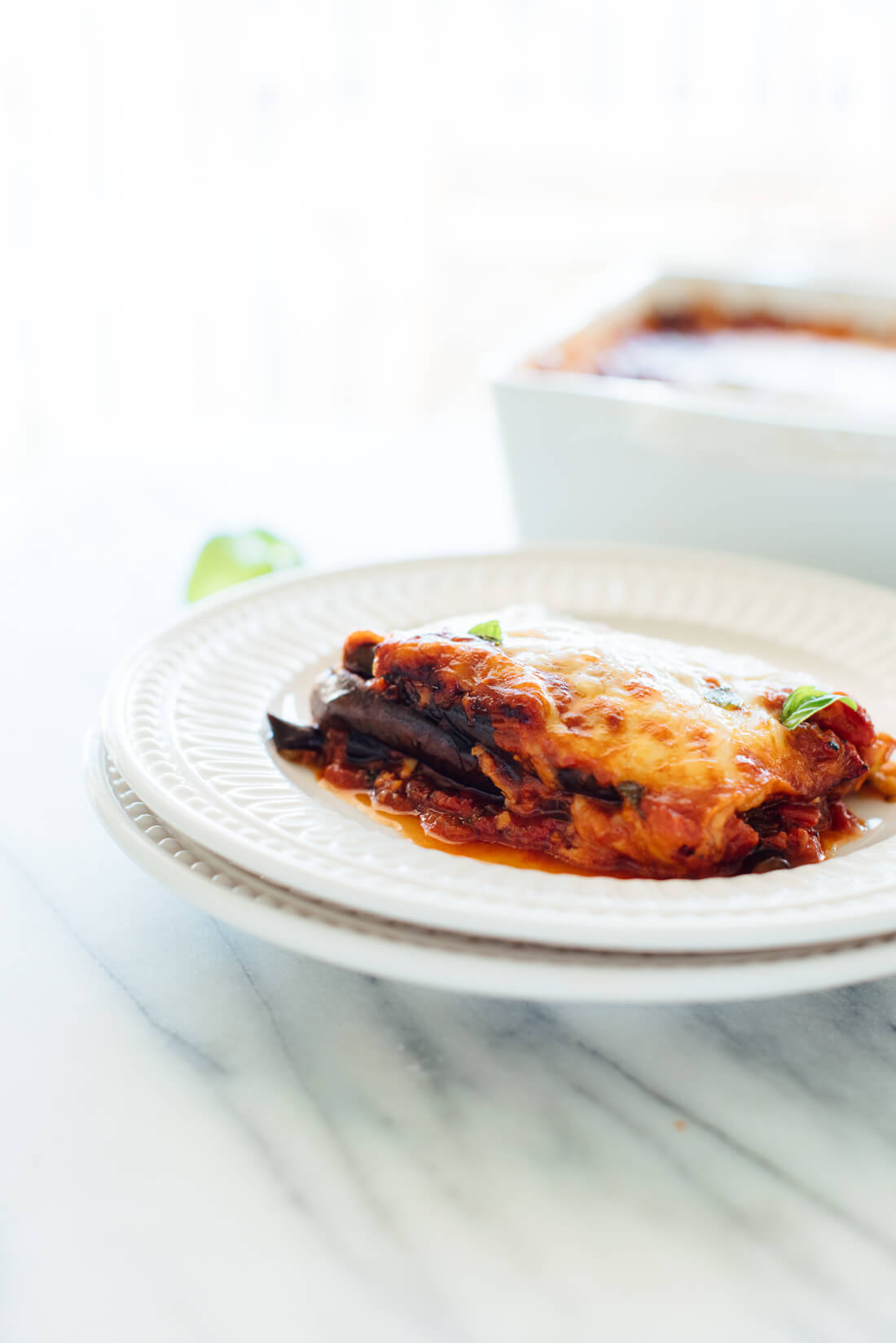 This Italian eggplant Parmesan recipe is lighter than mostโit's made with roasted eggplant slices (not fried) and no breading (you won't miss it). #vegetarian
