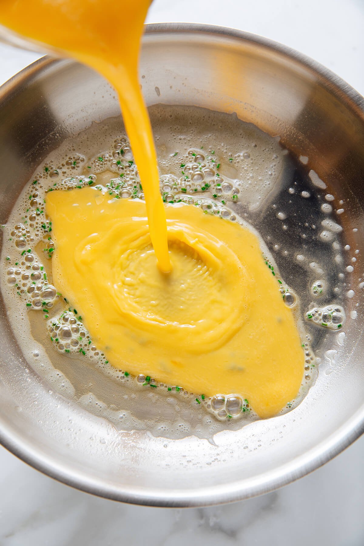 pouring eggs into pan